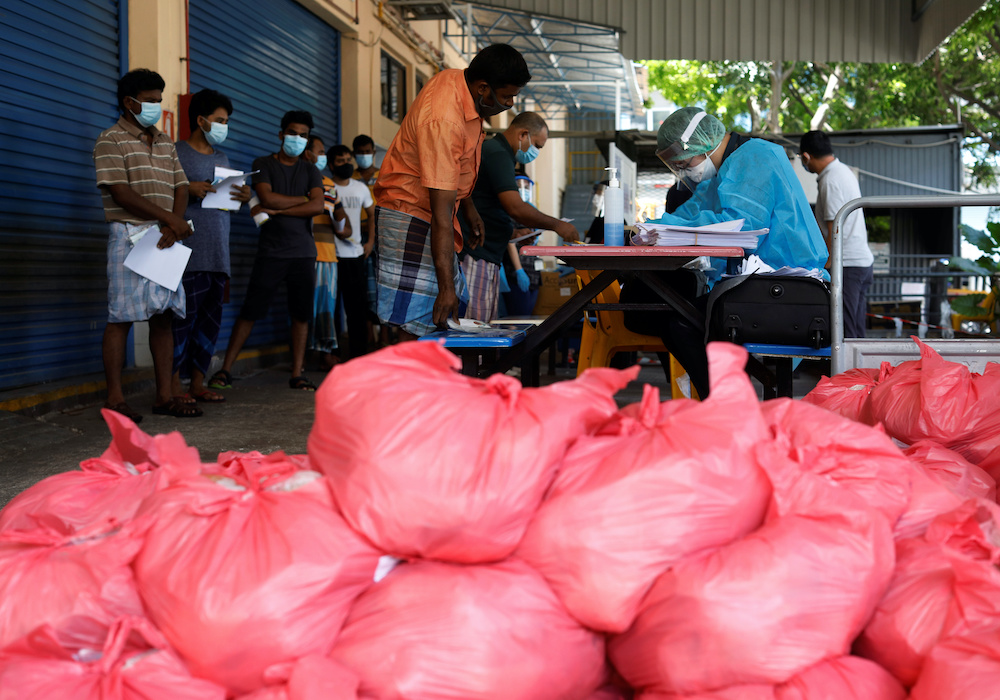 Migrant workers living in a factory-converted dormitory collect the food delivered by, non-governmental organization Alliance of Guest Workers Outreach during the coronavirus disease outbreak in Singapore April 22, 2020. u00e2u20acu201d Reuters picnn