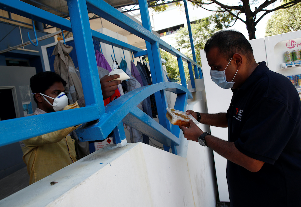 Reverend Samuel Gift Stephen listens to the feedback from a migrant worker about the food that had been delivered to them during the coronavirus disease outbreak in Singapore April 22, 2020. — Reuters pic
