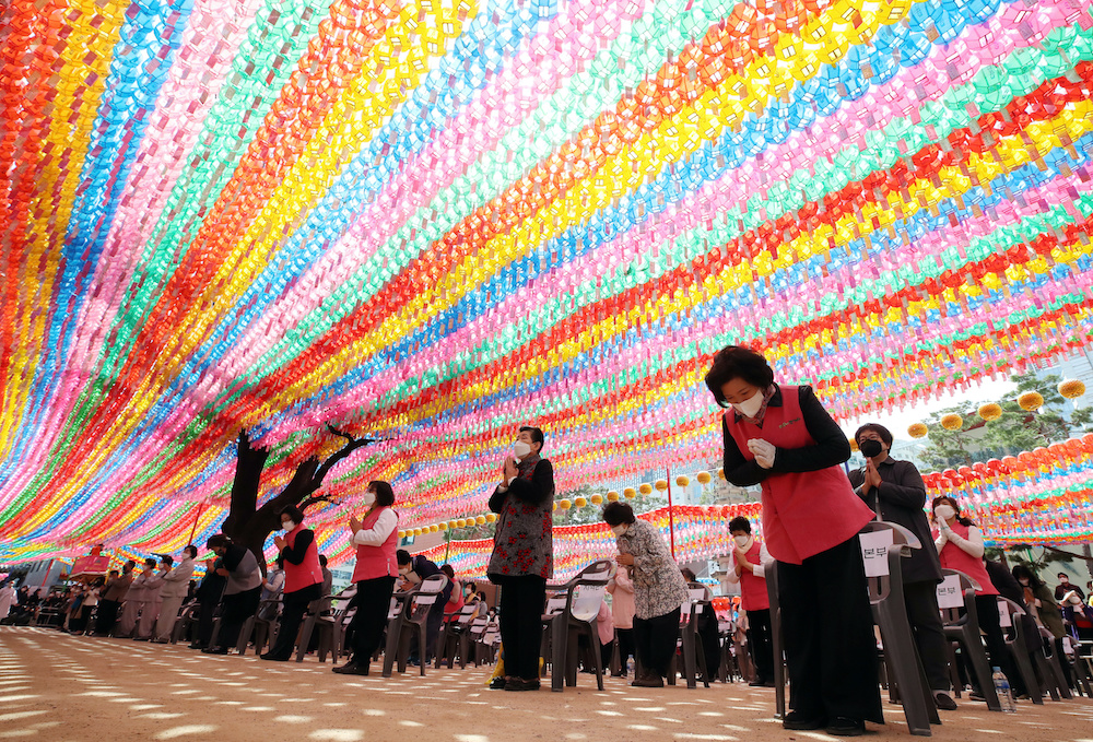 Buddhist believers attend an event to celebrate the birthday of Buddha as they keep their social distance under colourful lanterns at a temple in Seoul, South Korea, April 30, 2020. Yonhap. u00e2u20acu201d Reuters picnn