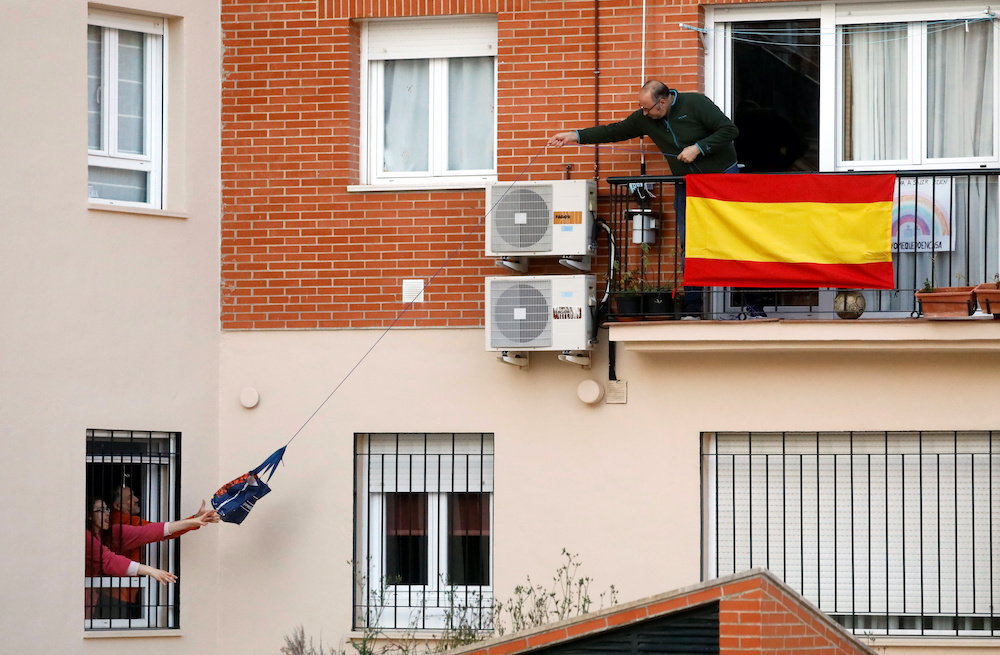 A man throws a bag with drinks to his neighbours, after the daily applause in support of healthcare workers, during the lockdown amid the coronavirus disease outbreak in Ronda, southern Spain, April 22, 2020. u00e2u20acu201d Reuters pic