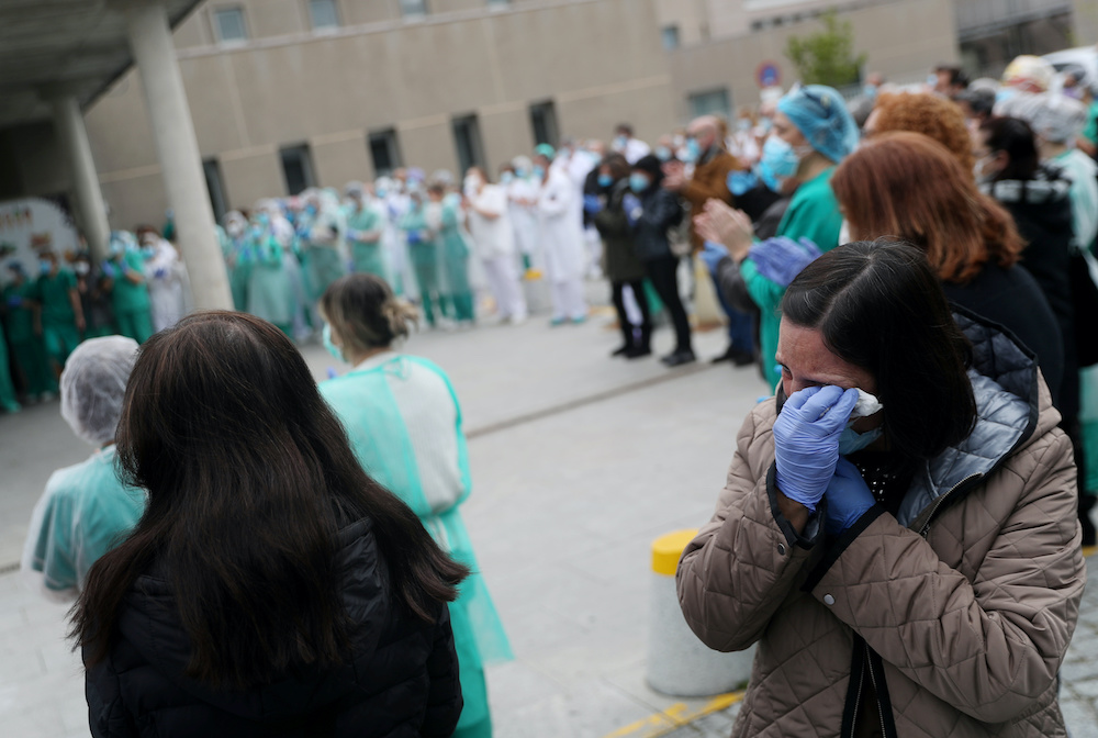 A woman reacts after a minutes silence outside Segovia’s General Hospital to remember hospital worker Marisol Sacristan, who died of Covid-19, amid the coronavirus disease outbreak in Segovia, Spain, April 23, 2020. ― Reuters pic