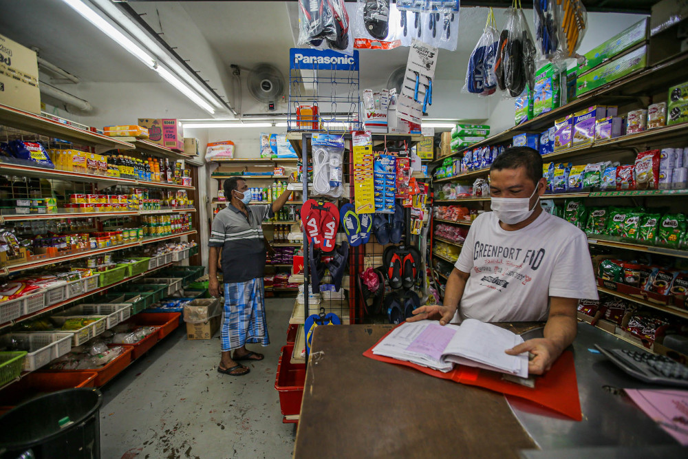 Shop supervisor Fahmi Leo checks his shopu00e2u20acu2122s supplies at the Taman Wilayah flats near the red zone area of Pasar Borong Kuala Lumpur April 21, 2020. u00e2u20acu201d Picture by Hari Anggara