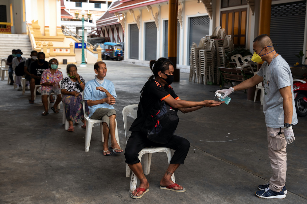 A volunteer wearing a face mask due to the spread of the coronavirus disease (Covid-19) gives hand gels to homeless people before they receiving food at the Wat Arun Ratchavararam in Bangkok Thailand, April 2, 2020. u00e2u20acu201d Reuters pic
