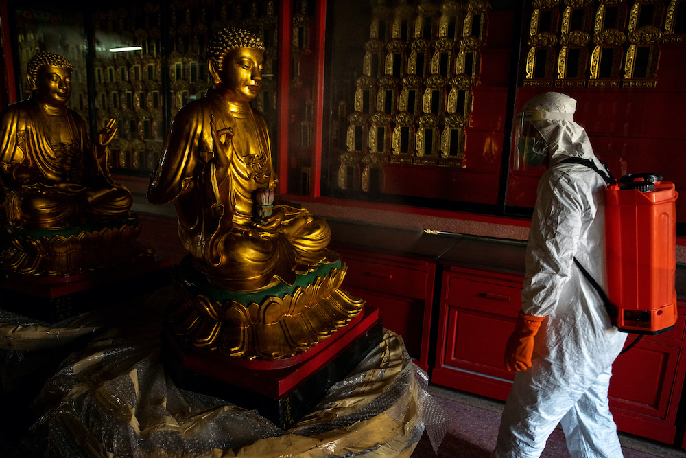 A volunteer wearing a protective gear sprays disinfectant while sanitizing at Wat Dibaya Varivihara due to the spread of the coronavirus disease (Covid-19) in Bangkok, Thailand, April 2, 2020. u00e2u20acu201d Reutersnn