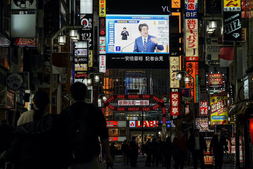 A large screen on a building shows Japan's Prime Minister Shinzo Abe declaring a state of emergency, at Tokyou00e2u20acu2122s famous entertainment district Kabukicho, following the coronavirus disease (Covid-19) outbreak, in Tokyo, Japan April 7, 2020. u00e2u20acu2022 Reuters pi