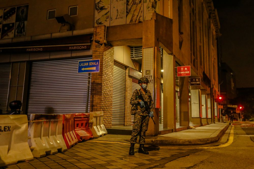 An Armed Forces personnel stands guard at an alley connecting Jalan Tuanku Abdul Rahman to Jalan Masjid India, which has been placed under the enhanced movement control order in Kuala Lumpur April 13, 2020. u00e2u20acu201d Picture by Firdaus Latif