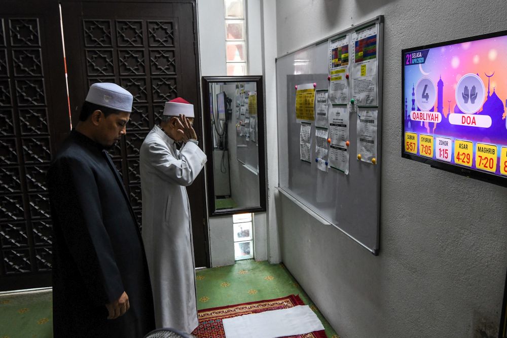 Imam Ramli Othman (right) and mosque bilal Sharifuddin Sulaiman perform Zuhur prayers at the At-Taqwa Mosque in Petaling Jaya April 21, 2020. u00e2u20acu201d Picture by Shafwan Zaidon