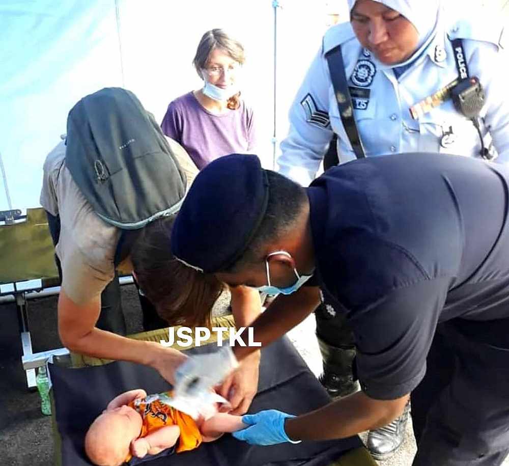 Kind police officers putting on diapers for the Russian couple's baby. u00e2u20acu201d Picture via Facebook/JSPTKL