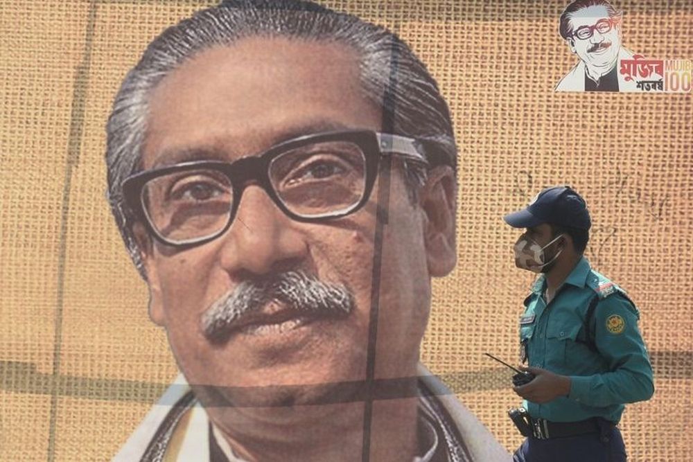In this file photo taken on March 09, 2020 a policeman wearing a facemask amid fears of the spread of the novel coronavirus, walks past a banner with a picture of Bangladeshu00e2u20acu2122s founder Sheikh Mujibur Rahman in Dhaka. u00e2u20acu201d AFP pic