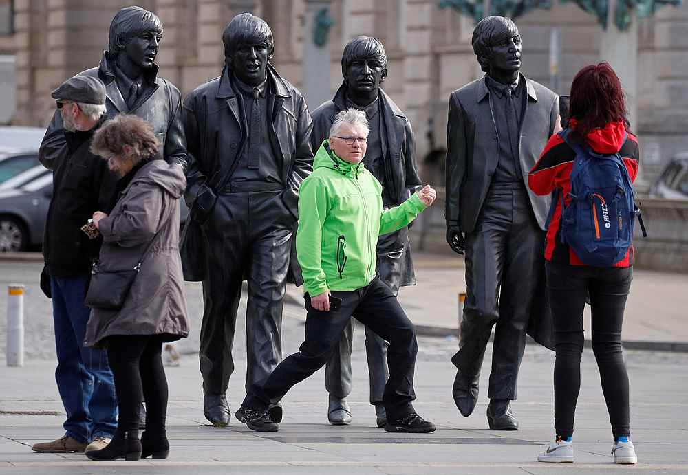 Tourists pose with statues of The Beatles, as the spread of the Covid-19 continues, in Liverpool, Britain March 17, 2020. u00e2u20acu201d Reuters pic