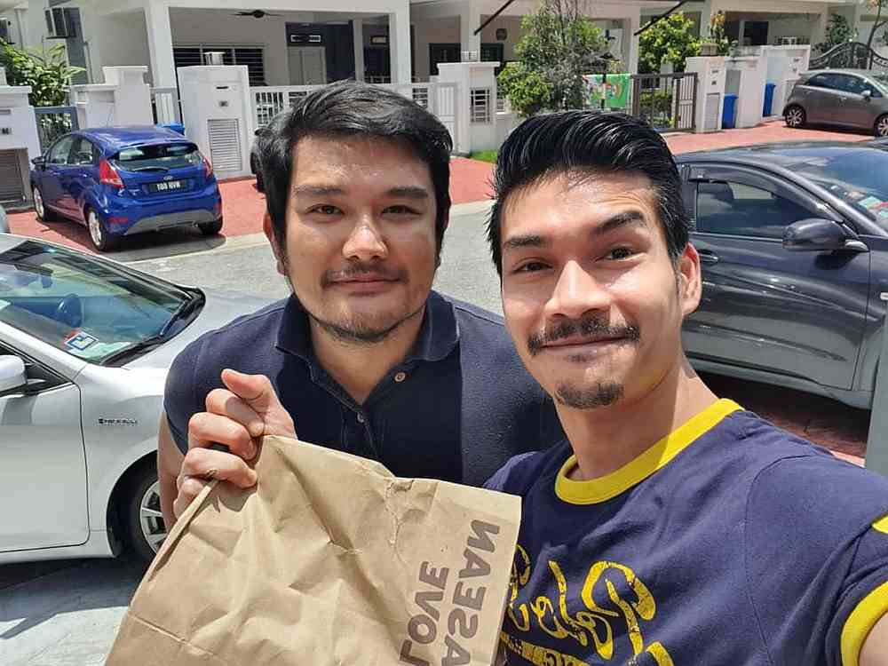 Benyamin (left) says he enjoys delivering food to customers and is keen to continue. — Picture courtesy of AirAsia