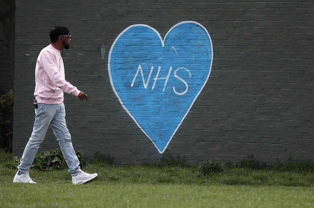 A man walks past a graffiti of a blue heart with the letters NHS, during lockdown to combat the Covid-19 outbreak in London, Britain April 8, 2020. u00e2u20acu201d Reuters pic