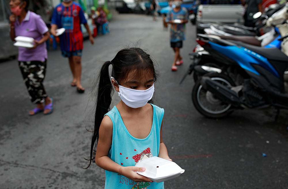 A girl wearing a protective face mask walks after she received free food at a slum area following the Covid-19 outbreak, in Bangkok, Thailand April 25, 2020. u00e2u20acu201d Reuters pic