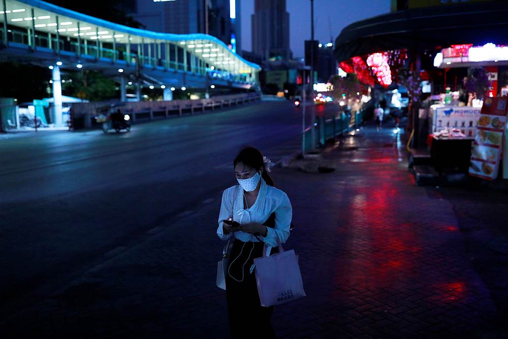 A woman wearing a protective mask looks at her phone as she walks on a street in Bangkok, Thailand, April 4, 2020. u00e2u20acu201d Reuters pic