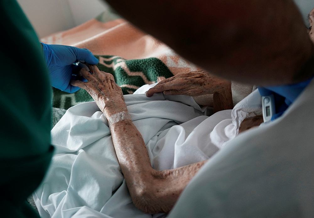 A health care worker caring for an elderly resident during lockdown amid the Covid-19 outbreak at Las Praderas nursing home in Pozuelo de Alarcon, Spain, April 23, 2020. u00e2u20acu201d Reuters pic