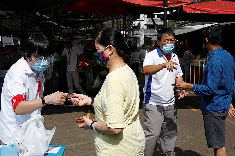 People have their identity cards checked ahead of buying groceries amid the Covid-19 outbreak in Singapore April 23, 2020. u00e2u20acu201d Reuters pic