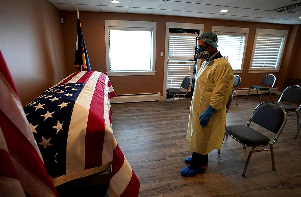Michael Neel, a funeral director, looks at the US flag on the casket of George Trefren, a 90-year-old Korean War veteran who died of Covid-19 in a nursing home, in Denver, Colorado April 23, 2020. u00e2u20acu201d Reuters pic