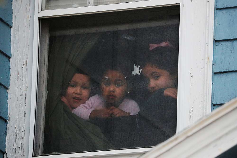 Children look out a window as an ambulance responds to a call amid the Covid-19 outbreak in Chelsea, Massachusetts April 17, 2020. u00e2u20acu201d Reuters pic