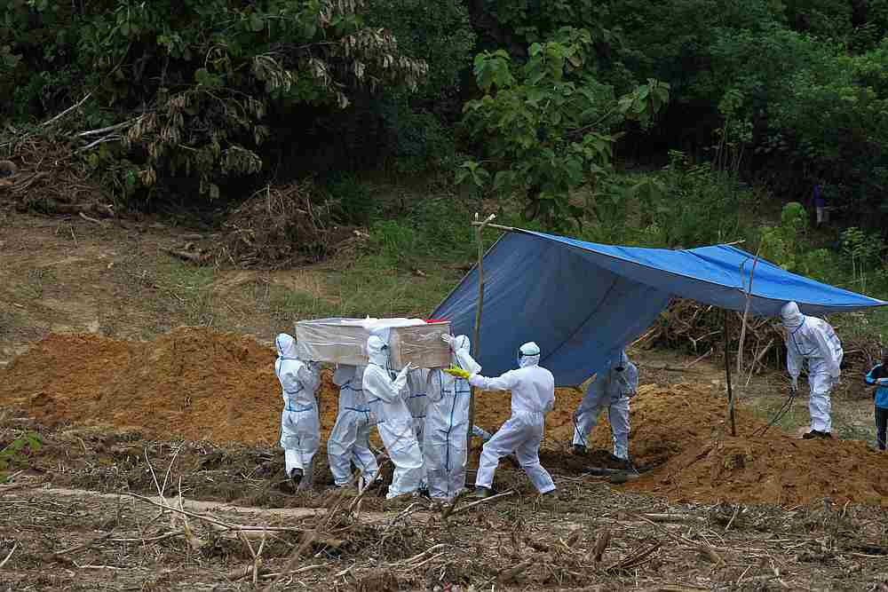 Medical officers wearing protective gears bury a victim of Covid-19 at a cemetery area provided by the government in Kendari, Southeast Sulawesi, Indonesia, April 18, 2020. u00e2u20acu201d Antara Foto/Jojon via Reuters