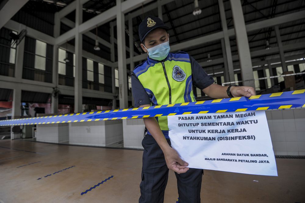 Petaling Jaya City Council officers cordon off the Taman Megah market from the public to make way for sanitisation work April 27, 2020. — Picture by Shafwan Zaidon