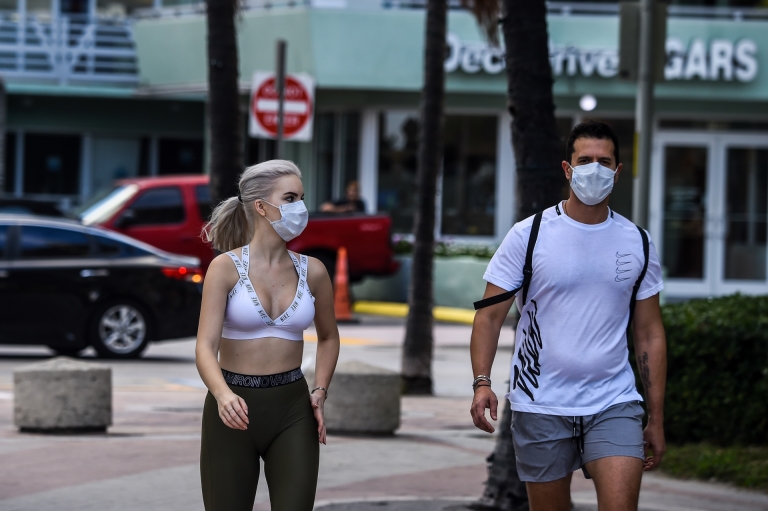 Tourists are seen wearing masks as they walk near the closed Miami Beach in Miami. u00e2u20acu2022 AFP pic