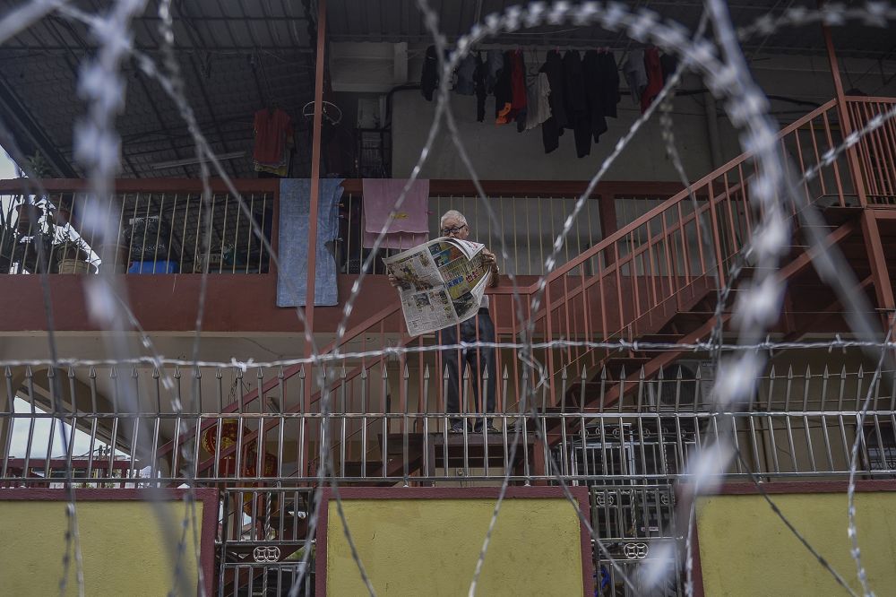 A man is seen reading a newspaper at home in Selayang Baru, amid the enhanced movement control order April 26, 2020. u00e2u20acu2022 Picture by Mera Zulyana