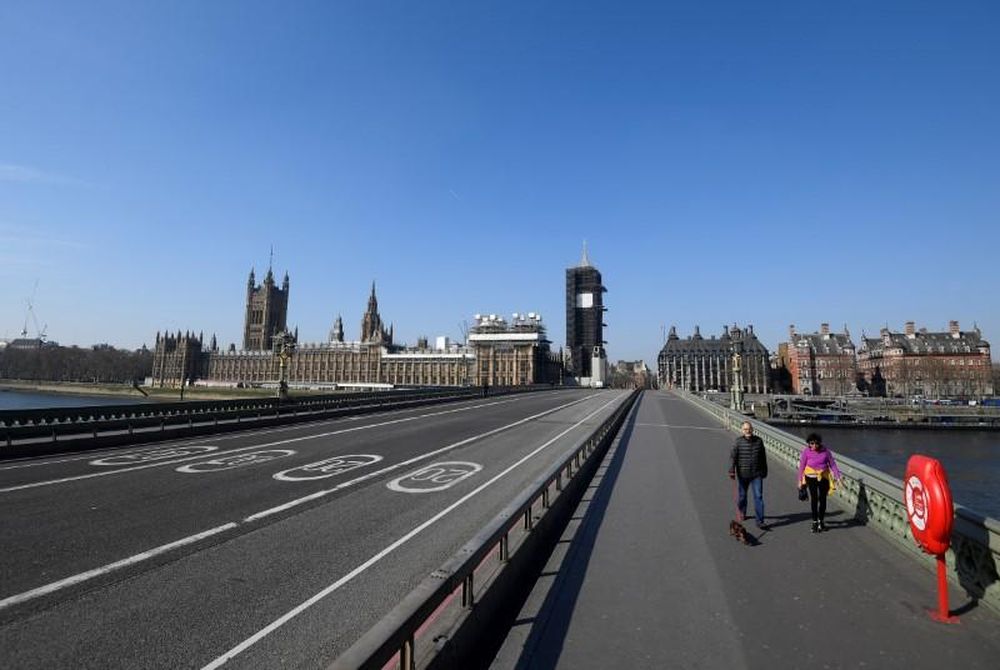 A couple walk their dog on an almost empty Westminster bridge as the spread of the coronavirus disease (Covid-19) continues, in London, Britain, March 26, 2020. u00e2u20acu201d Reuters pic