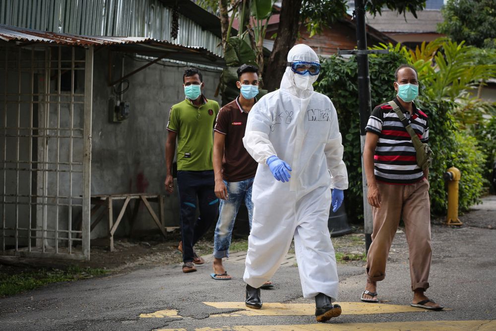 Foreign workers follow a Health Ministry personnel to be tested for Covid-19 in Kampung Baru, Kuala Lumpur April 14, 2020. u00e2u20acu201d Picture by Yusof Mat Isa