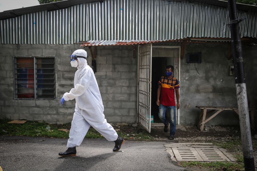 A foreign worker follows a Health Ministry personnel to be tested for Covid-19 in Kampung Baru, Kuala Lumpur April 14, 2020. u00e2u20acu201d Picture by Yusof Mat Isa