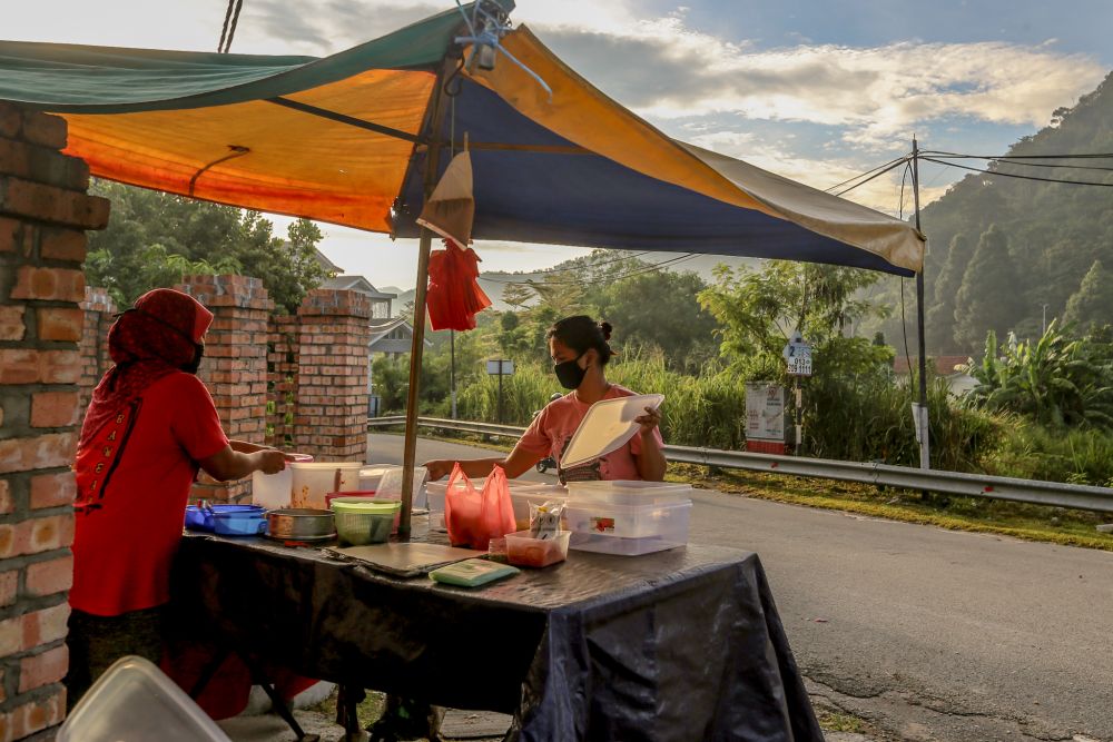 A nasi lemak vendor sets up shop during the movement control order in Gombak April 23, 2020. u00e2u20acu201d Picture by Firdaus Latif