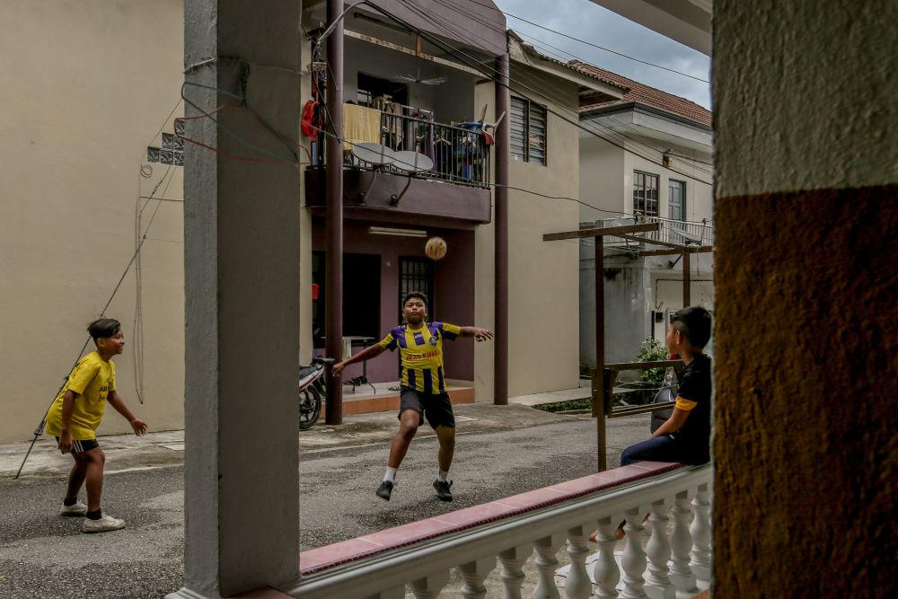 Children play sepak takraw in front of their houses in Gombak April 23, 2020. u00e2u20acu201d Picture by Firdaus Latif