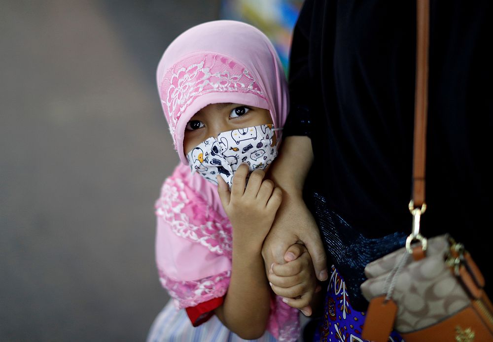 A girl is seen with her mother in a market, as the spread of the Covid-19 continues in Bangkok, Thailand April 23, 2020. u00e2u20acu201d Reuters pic