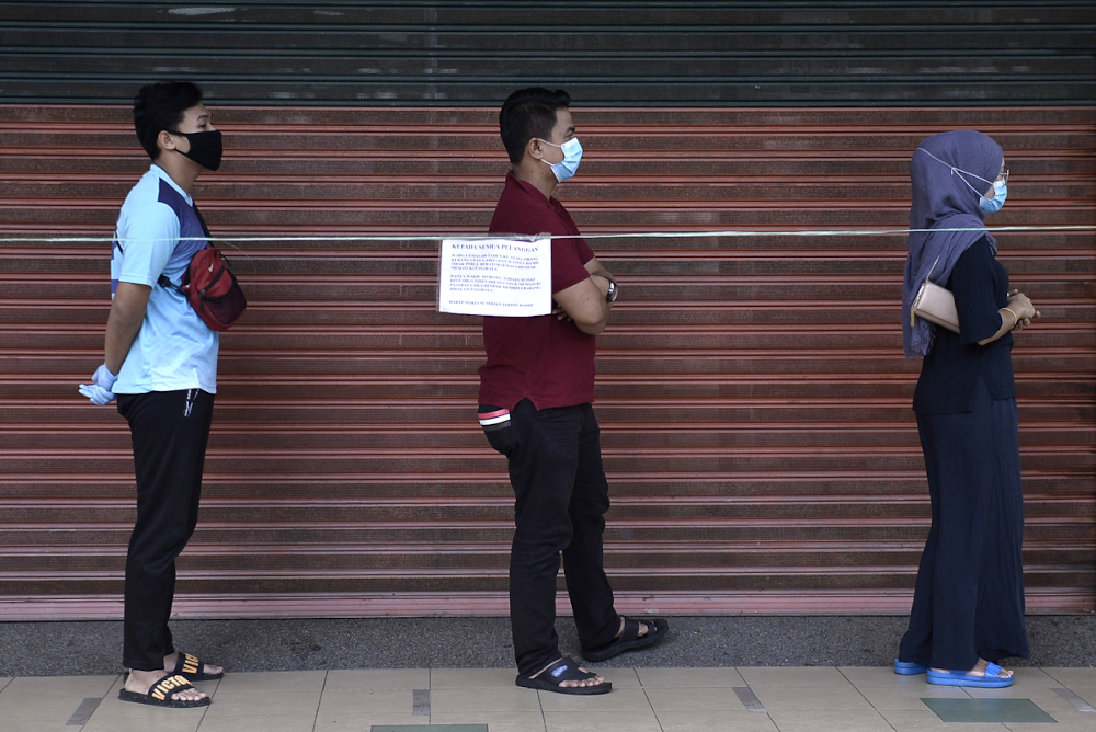 Shoppers line up to get groceries at OTK hypermarket in Puchong on April 1, 2020. u00e2u20acu201d Picture by Miera Zulyana