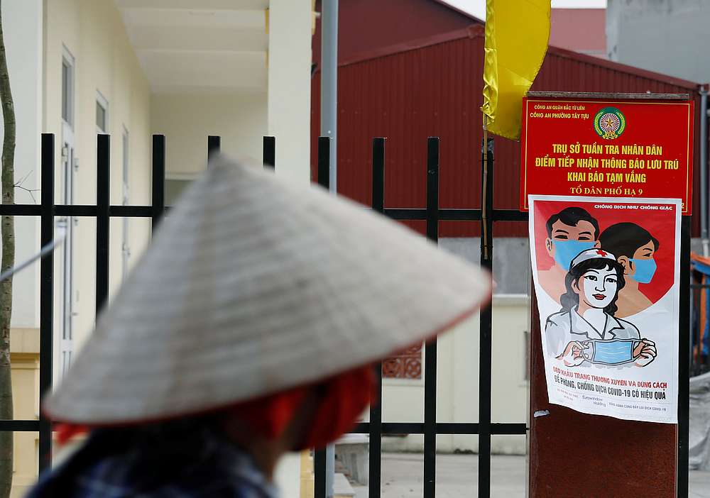 A farmer rides a bycycle past a poster warning about the Covid-19 outbreak in Hanoi, Vietnam April 22, 2020. u00e2u20acu201d Reuters pic