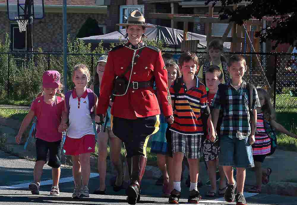 RCMP Constable Heidi Stevenson, who was shot and killed by a gunman April 19, 2020, walks children across a street in a September 2015 photograph. — RCMP in Nova Scotia handout via Reuters