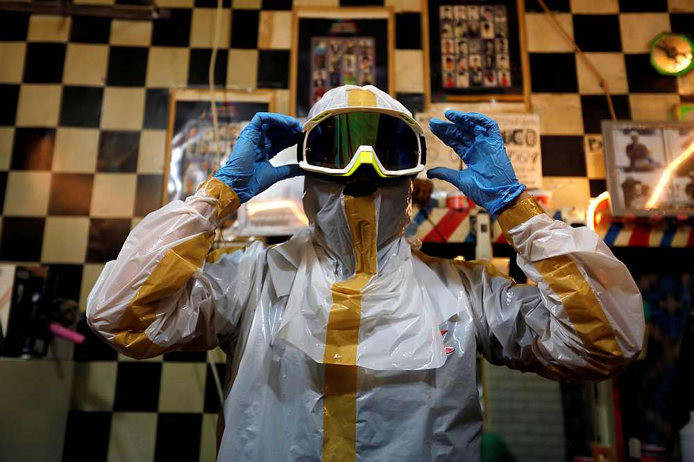 Hairstylist Herman Maulanasyah prepares his handmade protective suit before giving a haircut to a customer in Bogor, Indonesia April 6, 2020. u00e2u20acu201d Reuters pic