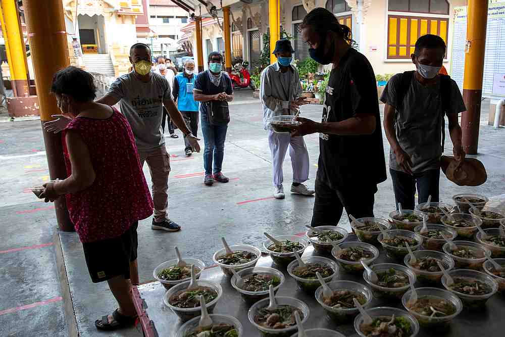 Homeless people queue for their food and follow social distancing rules at the Wat Arun Ratchavararam in Bangkok, Thailand April 2, 2020. u00e2u20acu201d Reuters pic