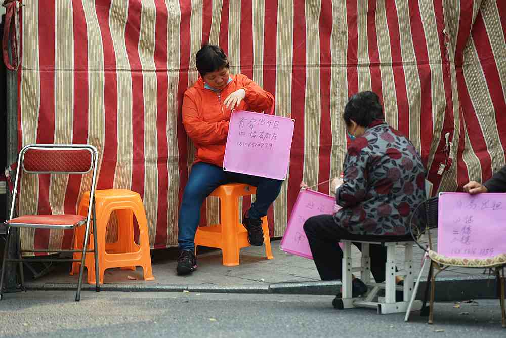 Landlords hold signs with home rental information at an entrance to an urban village in Hangzhou, Zhejiang province, China April 19, 2020. u00e2u20acu201d China Daily pic via Reuters
