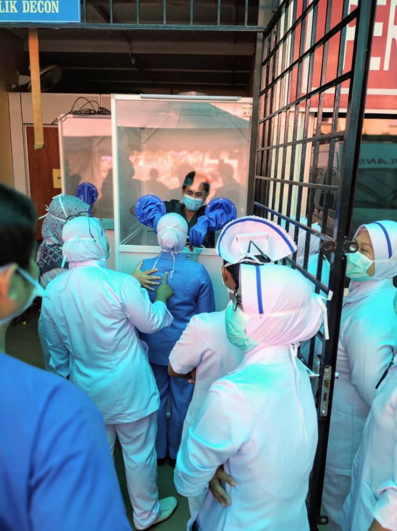 Medical personnel in Ipoh's Hospital Raja Permaisuri Bainun show how the swabbing booth works after the handing over ceremony on Friday. ― Picture courtesy of Lai Jen Hong