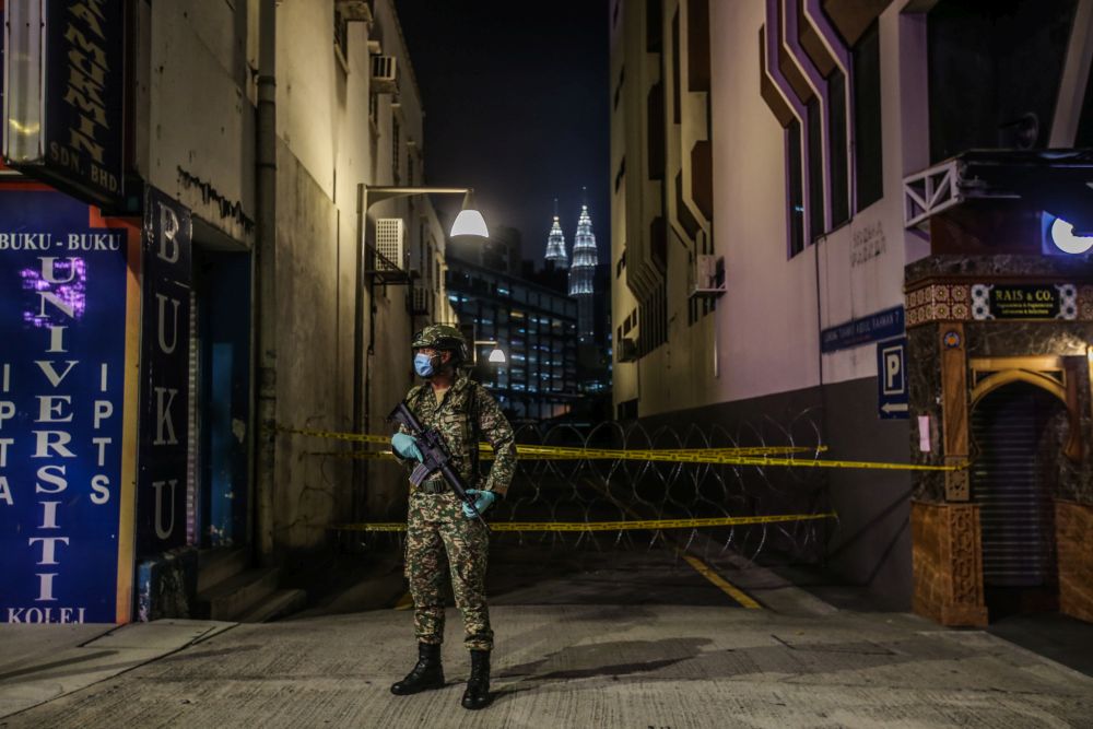 An Armed Forces personnel stands guard at an alley connecting Jalan Tuanku Abdul Rahman to Jalan Masjid India, which has been placed under the enhanced movement control order in Kuala Lumpur April 14, 2020. u00e2u20acu201d Picture by Hari Anggara
