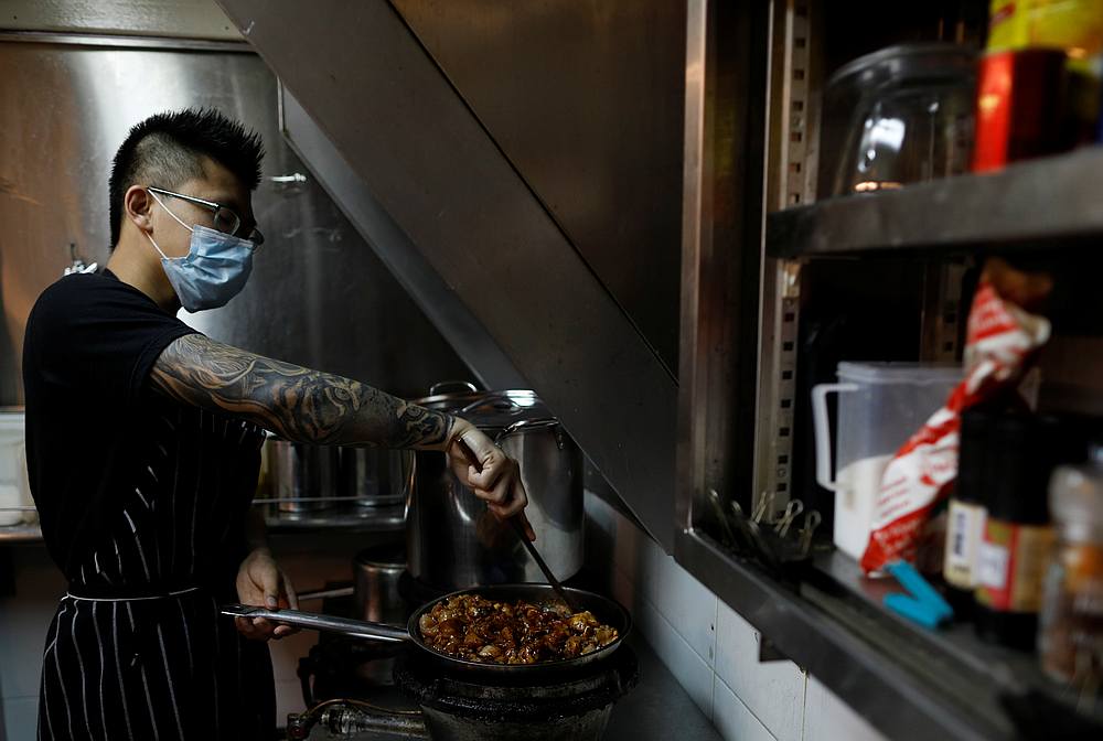 Hawker Jason Chua cooks in his stall at Hong Lim Market & Food Centre, amid the Covid-19 outbreak in Singapore April 27, 2020. u00e2u20acu201d Reuters pic