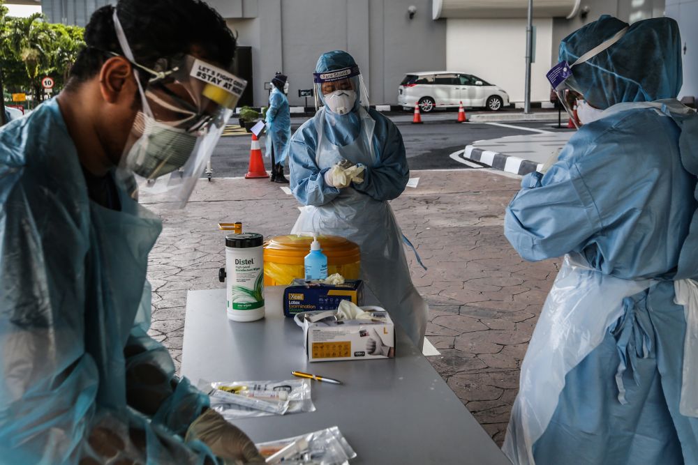 Health workers suit up at a drive-through testing site for Covid-19 at KPJ Ampang Puteri, April 6, 2020. u00e2u20acu201d Picture by Firdaus Latif