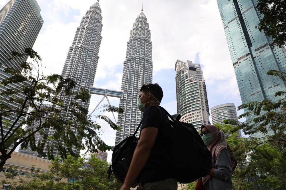 Tourists wearing masks pass by Petronas Twin Towers in Kuala Lumpur, Malaysia, January 31, 2020. u00e2u20acu201dReuters pic