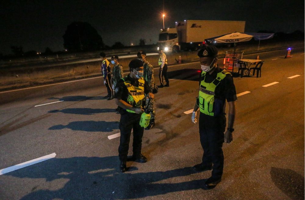 Policemen work round the clock during a roadblock in Ipoh as the movement control order enters phase three on April 15, 2020. u00e2u20acu201d Picture by Farhan Najib
