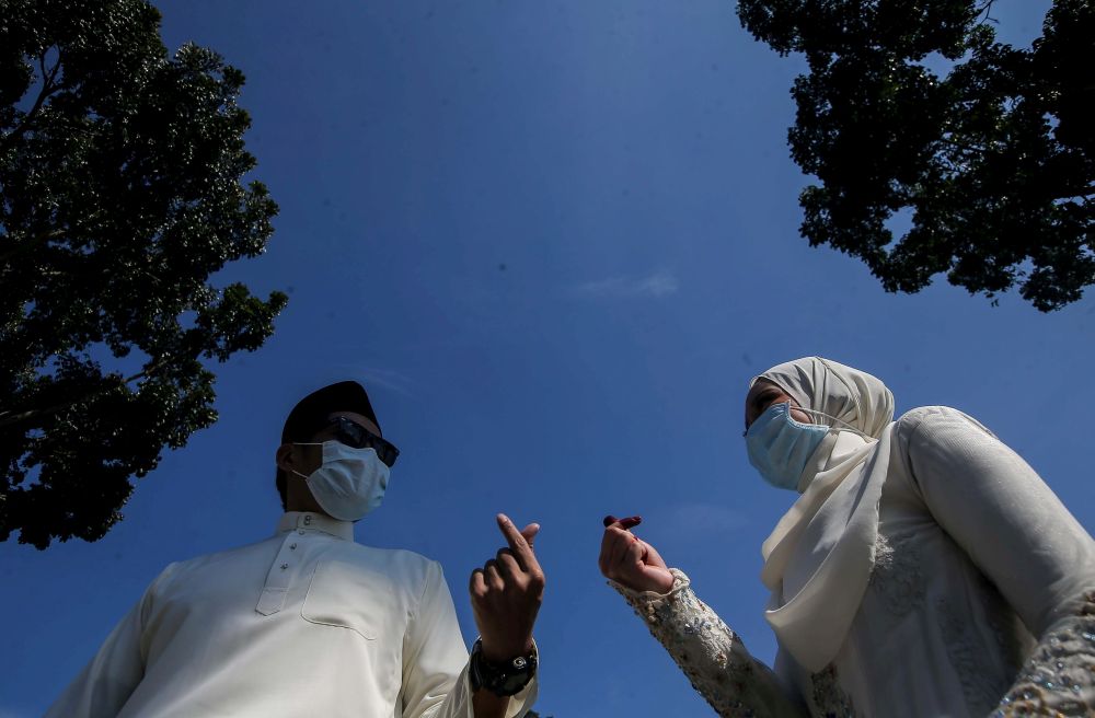 Newly-wed couple Mohd Hanif Zamri and Nur Afiqah Abdul Ghaffar strike a pose after performing their u00e2u20acu02dcnikahu00e2u20acu2122 vows at the Ipoh District Islamic Religious Office April 22, 2020. u00e2u20acu201d Picture by Farhan Najib