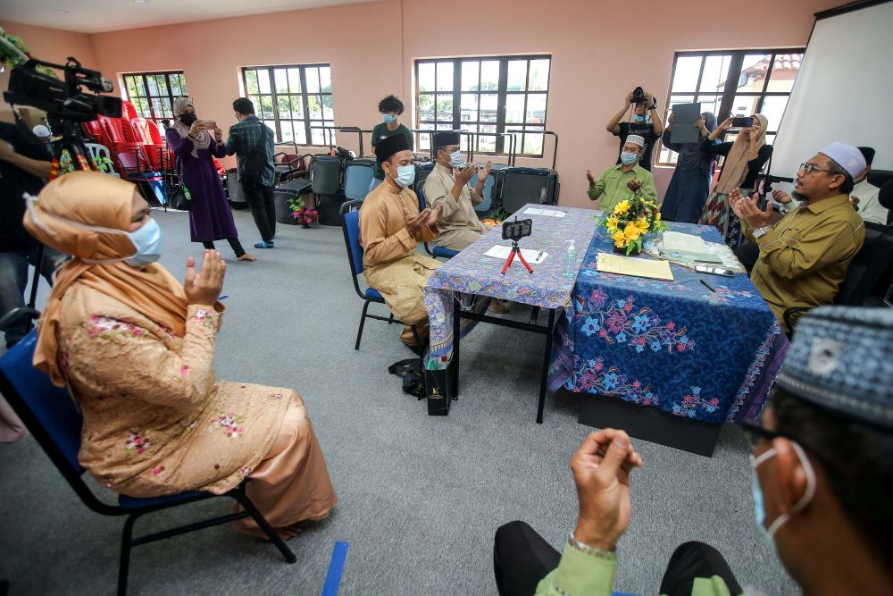 A couple observe social distancing guidelines while performing their u00e2u20acu02dcnikahu00e2u20acu2122 vows at the Ipoh District Islamic Religious Office April 22, 2020. u00e2u20acu201d Picture by Farhan Najib