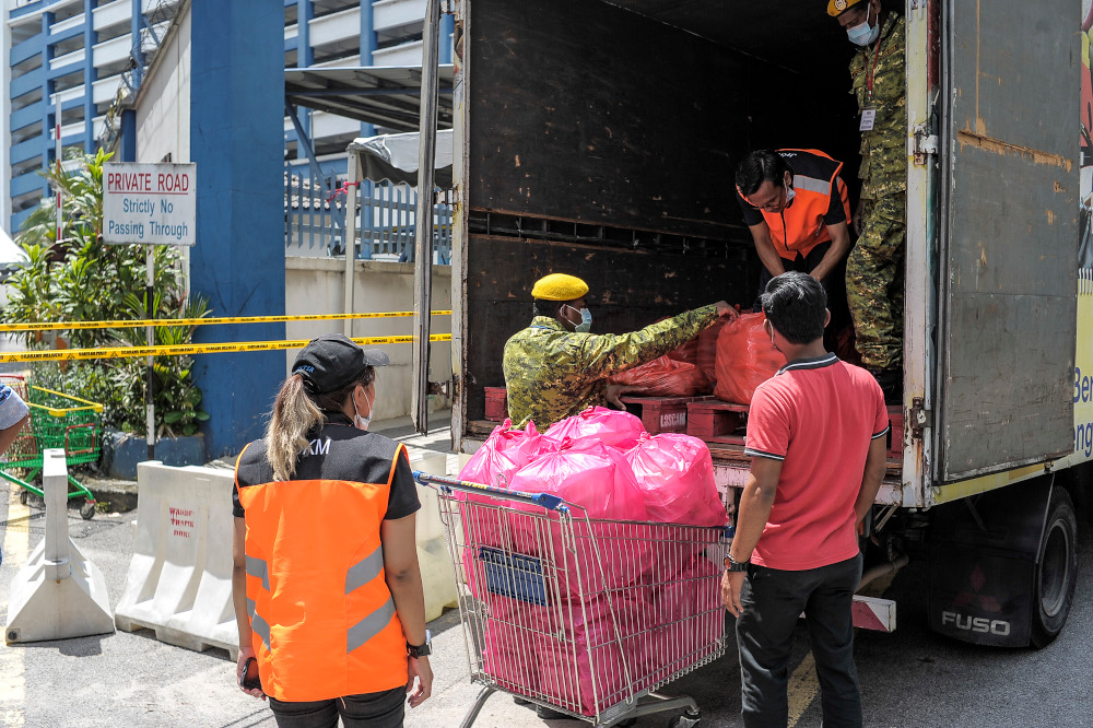 Social Welfare Department staff distribute meal packs for Plaza City One residents in Kuala Lumpur, April 15, 2020 u00e2u20acu201d Picture by Shafwan Zaidon