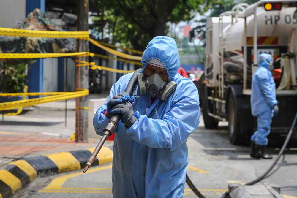 Alam Flora personnel spray disinfectant in front of the Menara Plaza City One in Kuala Lumpur April 2, 2020. u00e2u20acu2022 Picture by Yusof Mat Isa