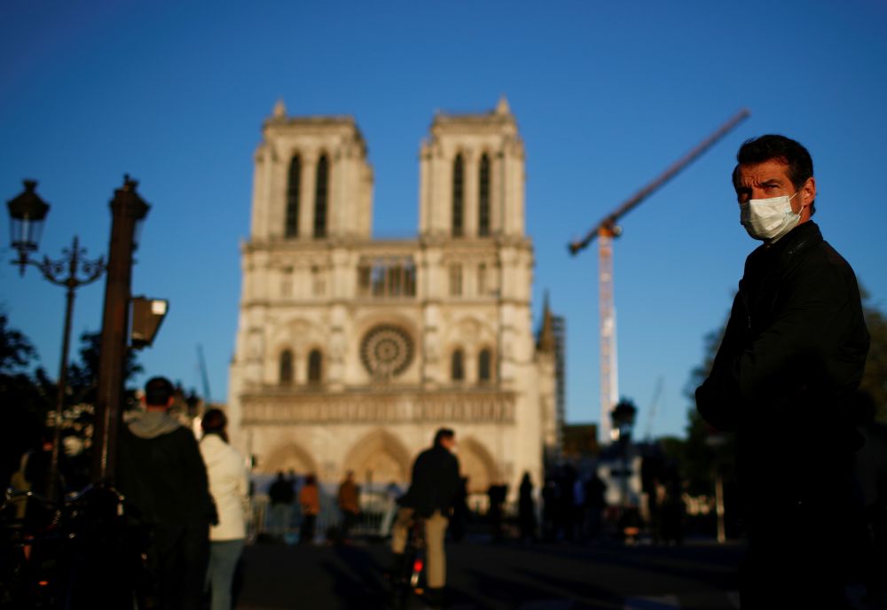A man wearing a face mask listens to the Notre-Dame de Paris Cathedral's great bell ringing, as a mark of the building's resilience one year after a devastating fire April 15, 2020. u00e2u20acu201d Reuters pic