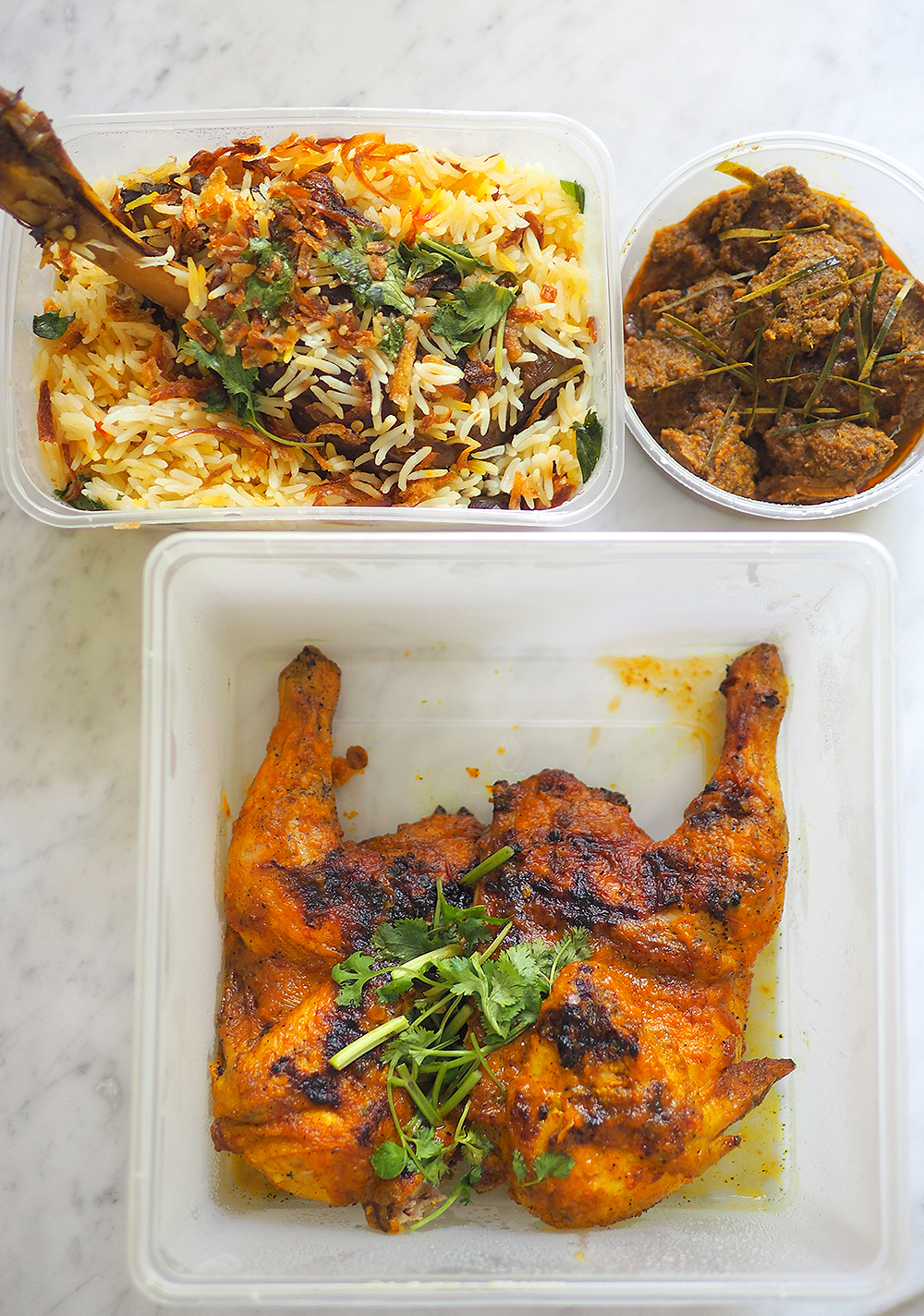 Each box is labelled with the name of the dish and covered with plastic wrap to prevent spillage or any tampering.